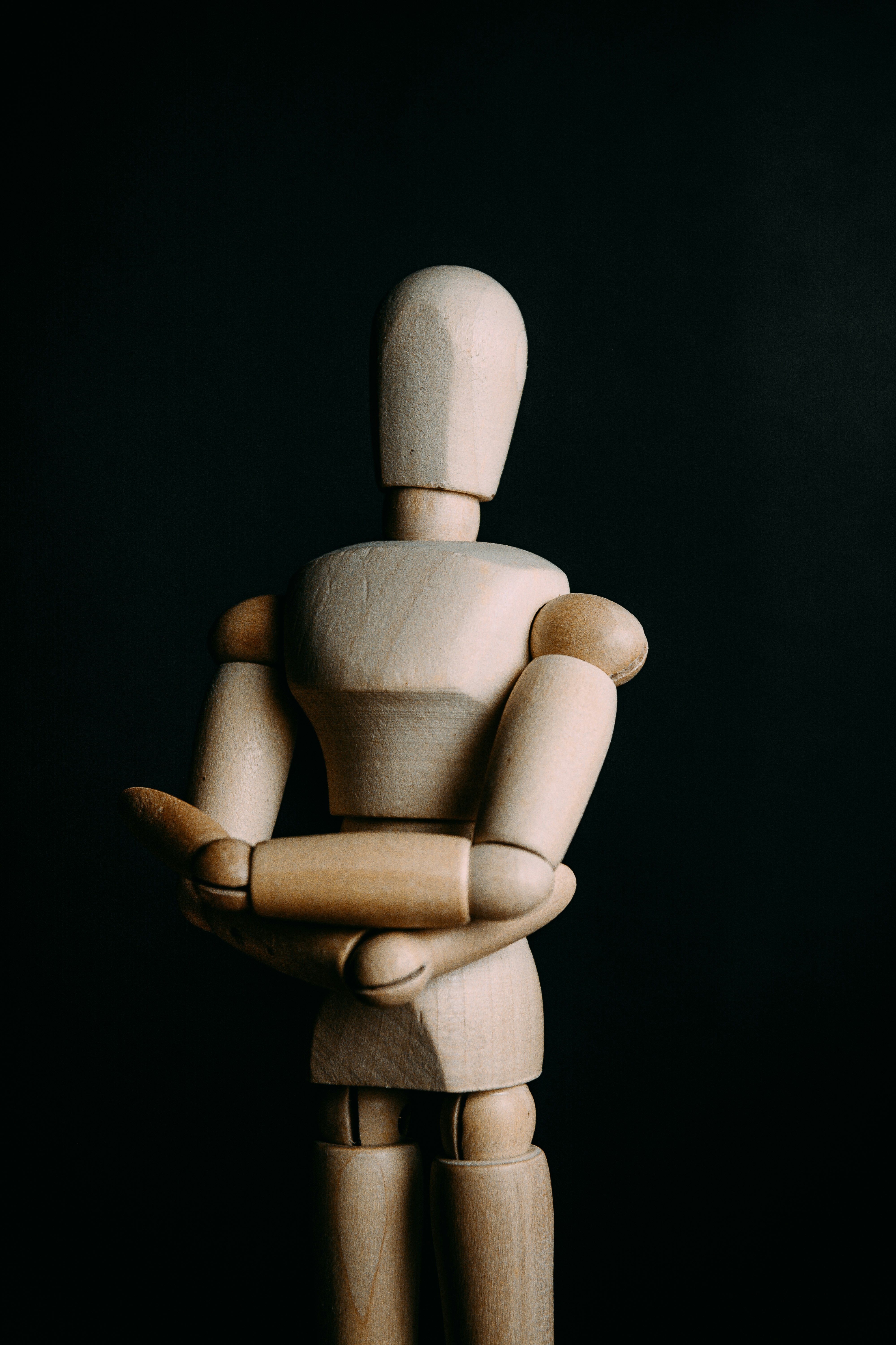 brown wooden human figurine on black surface